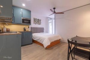 a bedroom with a bed and a kitchen with a ceiling fan at Moderno y funcional apartamento en el centro-El rastro in Madrid