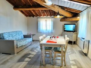 una sala de estar con una mesa y un sofá en Moraiolo Podere le Bozze con piscina WI-FI, en Castagneto Carducci