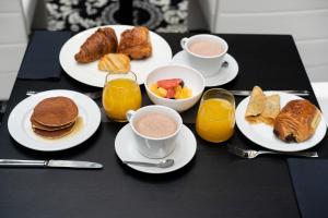 a table with plates of breakfast foods and cups of coffee at Le Grand Hôtel Le Touquet-Paris-Plage in Le Touquet-Paris-Plage