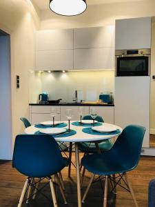 een keuken met een tafel met 4 stoelen en een keuken met een keuken bij Victus Apartamenty, Apartament Omega in Sopot