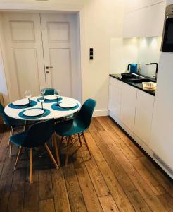 a kitchen with a table and chairs in a room at Victus Apartamenty, Apartament Omega in Sopot