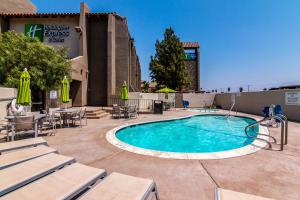 una piscina con mesas y sillas y un edificio en Holiday Inn Express & Suites Camarillo, an IHG Hotel, en Camarillo