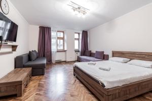 ein Schlafzimmer mit einem Bett, einem Sofa und einem TV in der Unterkunft Bon View Apartment in Lwiw
