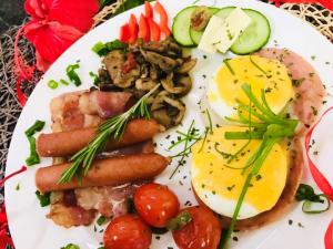 einen Teller mit Eiern, Wurst und Gemüse in der Unterkunft Oliver's Bed and Breakfast in Mtunzini