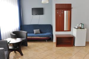 a living room with a blue couch and a table at Hotel Elda 2 in Bydgoszcz