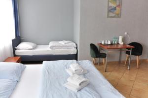 a hotel room with two beds and a table with a table at Hotel Elda 2 in Bydgoszcz