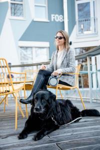 
a woman sitting on a bench with a dog at Airbase Hotel in Kalsdorf bei Graz
