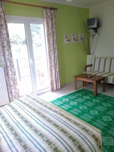 een slaapkamer met een bed, een tafel en een raam bij Ktima Ampares in Karpenisi