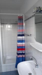 een badkamer met een wastafel en een douchegordijn bij Seevilla Wietjes Whg 6 in Baltrum