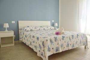 Schlafzimmer mit einem Bett mit einer blauen und weißen Bettdecke in der Unterkunft Campitur in Campomarino