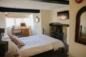 a bedroom with a fireplace and a bed at OYO Unicorn Inn in Banbury