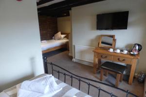 a bedroom with a bed and a tv at OYO Unicorn Inn in Banbury