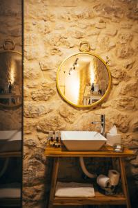 a bathroom with a sink and a mirror on a stone wall at Hotel Anilevich Mansion in Beer Sheva