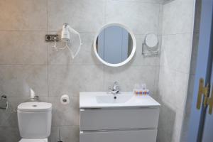 a bathroom with a toilet and a sink and a mirror at Ramblas Hotel in Barcelona