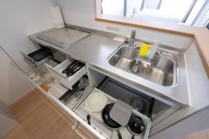 a small kitchen with a sink and a counter at Beans Stay Ishibiki in Kanazawa