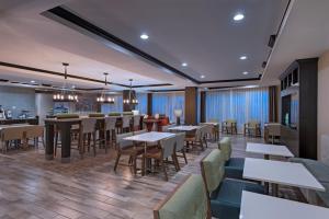 a restaurant with tables and chairs and a bar at Holiday Inn Express & Suites Austin NW - Four Points, an IHG Hotel in Four Points
