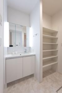a white bathroom with a sink and a mirror at Beans Stay Ishibiki in Kanazawa +13 photos