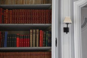 a book shelf filled with lots of books next to a door at Chambres d'hôtes au Château de Gizeux in Gizeux