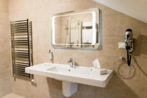 y baño con lavabo blanco y espejo. en Hotel Gradina Morii, en Sighetu Marmaţiei