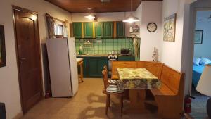 a kitchen with green cabinets and a table and a refrigerator at Casas del Abra Vieja in Tigre