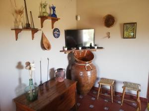 sala de estar con TV, mesa y sillas en Finca El Palomar, en Fuenteheridos