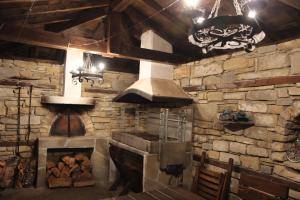 a kitchen with a stove and a stone wall at New Bakalov House in Bozhentsi