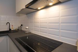 a kitchen with a sink and white tile wall at BEST LOCATION ON MAIN SQUARE p4you pl in Krakow