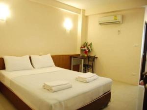 1 dormitorio con 1 cama con toallas en Rambuttri House en Bangkok