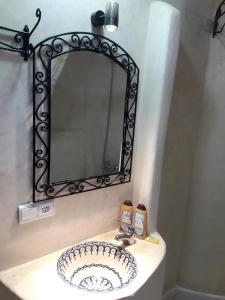 a bathroom sink with a mirror above it at Casa El Haouta in Chefchaouen