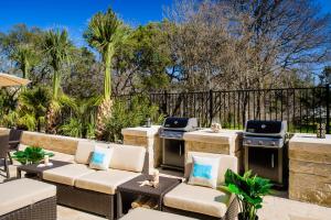 a patio with a grill and chairs and trees at Holiday Inn Express Hotel & Suites Austin NW - Arboretum Area, an IHG Hotel in Austin