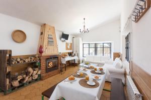 ein Wohnzimmer mit 2 Tischen und einem Kamin in der Unterkunft Albergue Sierra Norte in Manjirón