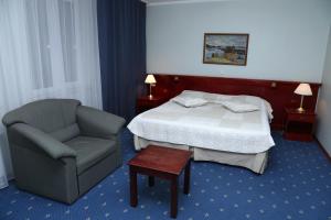 Un pat sau paturi într-o cameră la Draakon Hotel