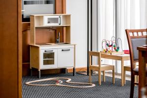 a room with a kitchen with a microwave and a table at Hotel Almarco in Środa Wielkopolska