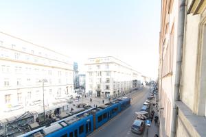 a blue train is on a city street with cars at BEST LOCATION ON MAIN SQUARE p4you pl in Krakow