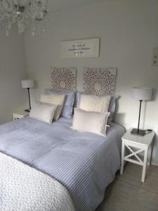 Un dormitorio con una cama con sábanas y almohadas azules y blancas en B&B Le Petit Atelier Du 44b, en Namur