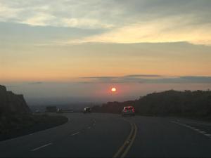 un coche conduciendo por una carretera con la puesta de sol en BOULEVARD departamentos en Mina Clavero