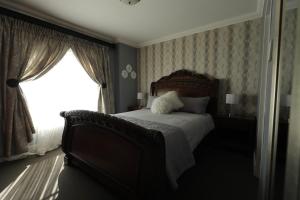a bedroom with a large bed and a window at The View - Luxury Apartment in eMalahleni