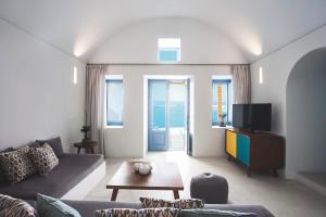ein Wohnzimmer mit einem Sofa und einem TV in der Unterkunft Remezzo Villas in Imerovigli