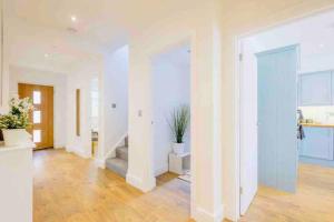 a living room with white walls and wooden floors at Gorgeous Luxury Chalet, New Forest & Coast & in Hordle +120 photos