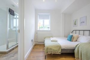 1 dormitorio con cama y ventana en Gorgeous Luxury Chalet, New Forest & Coast & en Hordle