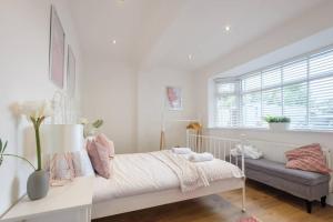 a white bedroom with a bed and a window at Gorgeous Luxury Chalet, New Forest & Coast & in Hordle