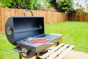 a barbecue grill sitting on a picnic table in a yard at Gorgeous Luxury Chalet, New Forest & Coast & in Hordle
