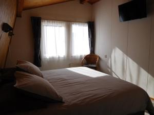 een slaapkamer met een wit bed met een raam bij Wijngaardstraat 7a Domburg in Domburg