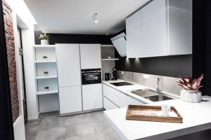 una cocina blanca con paredes negras y armarios blancos en Smartflats - Bourse Brussels en Bruselas