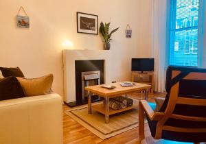 uma sala de estar com uma mesa e uma lareira em The St Mary's Street Residence em Edimburgo