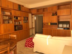 - un salon avec des placards en bois et un canapé blanc dans l'établissement Questa casa non è un albergo CIU-ATR 9390-9, à Rome