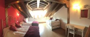Un dormitorio con 2 camas y una mesa en una habitación en El Palacio del Campo, en Servillas