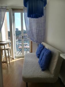 Habitación con balcón y sofá con almohadas azules. en Oportobestview-Sun, en Oporto