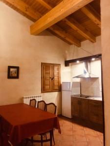 a kitchen and dining room with a table and a stove at La Casa del Cartero Pablo in Saldaña de Ayllón