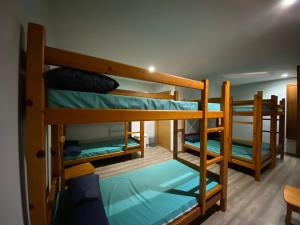 a room with three bunk beds in a room at Albergue Pereiro in Melide